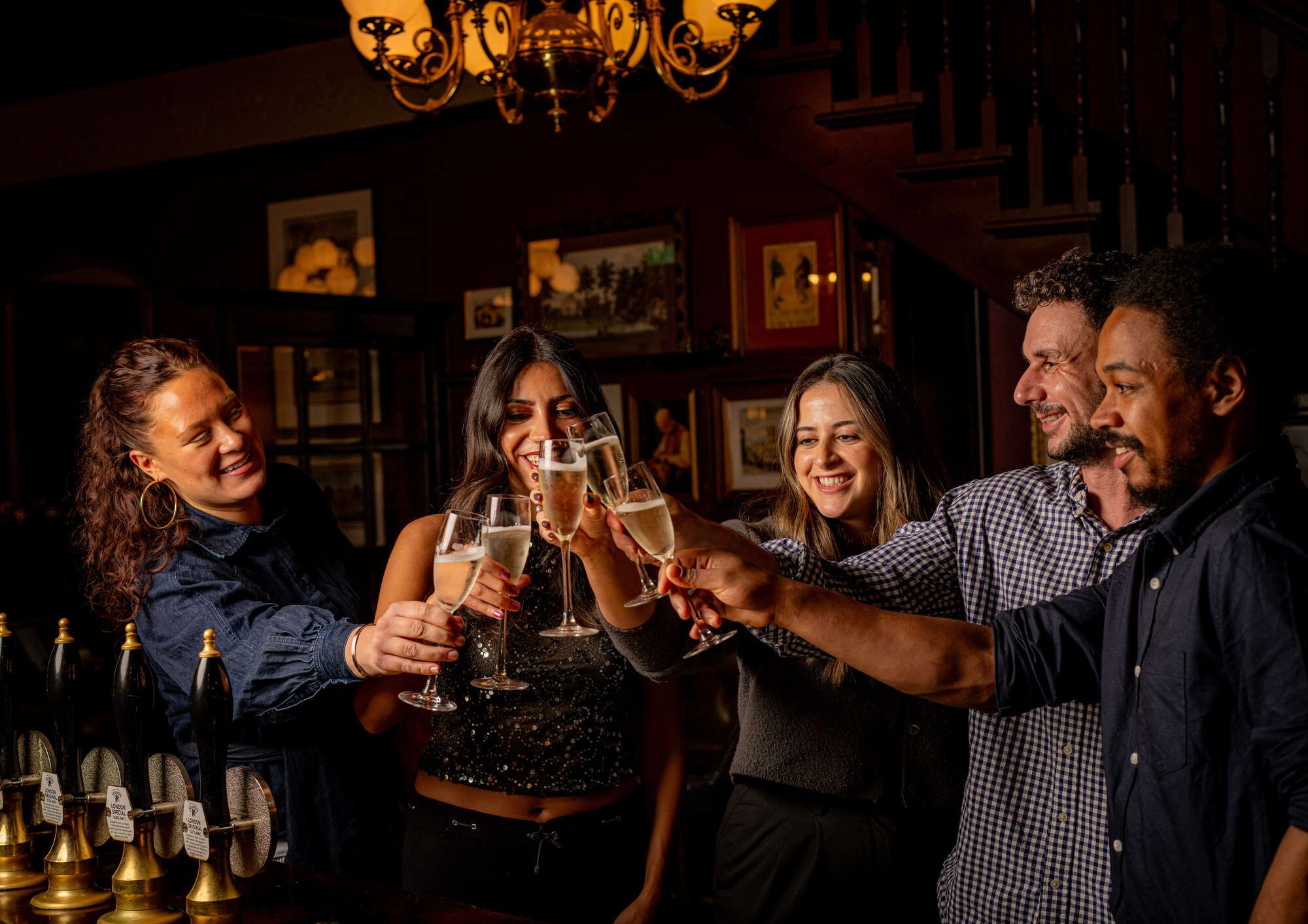 Friends cheers with glass of bubbles in a cosy pub