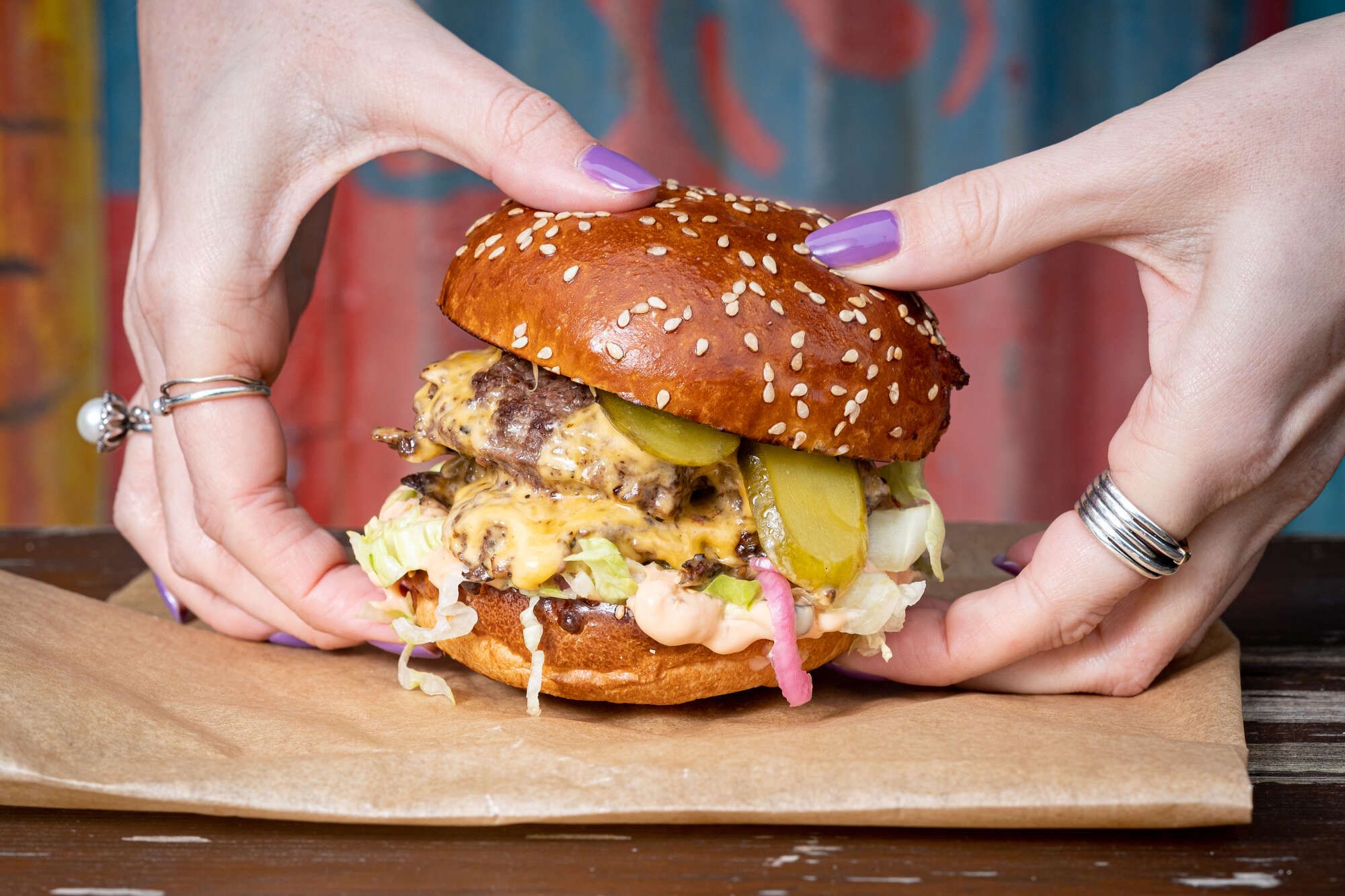 Women holding a very juicy beef burger for the Burger Shack